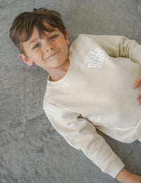Our World Needs Jesus Beige Kids Crewneck Christian Sweatshirt